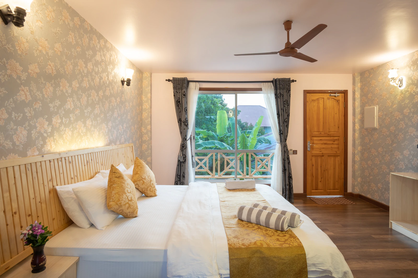 A villa-style deluxe room with a sofa and balcony at Ostrov Palm Villa