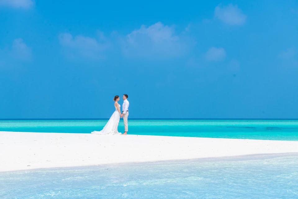 Wedding couple posing beside turquoise lagoon water