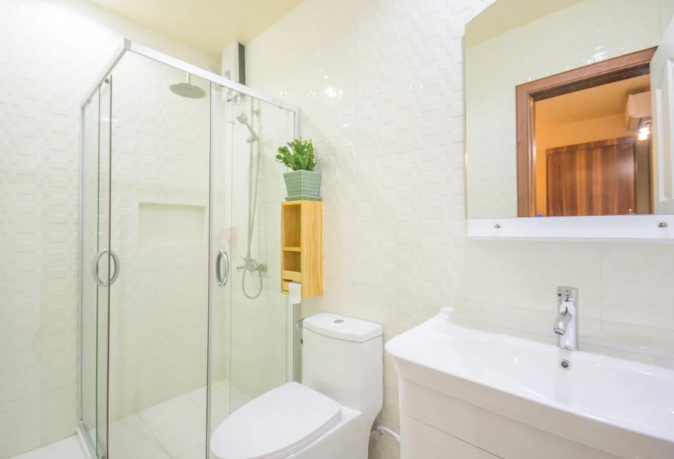 Bathroom with glass shower, toilet, vanity, and mirror