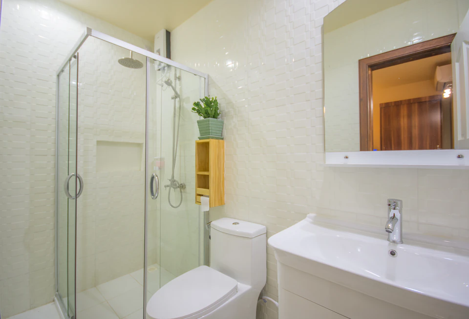Alternate bathroom angle with glass shower, toilet, and vanity