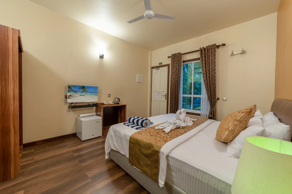 Alternate double-bed room view toward the television and window