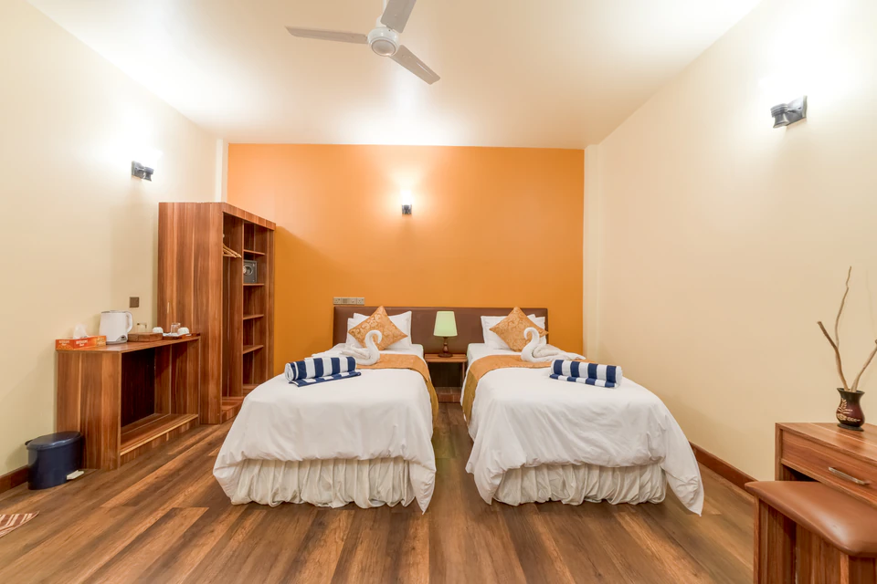 Front view of twin beds against the orange accent wall