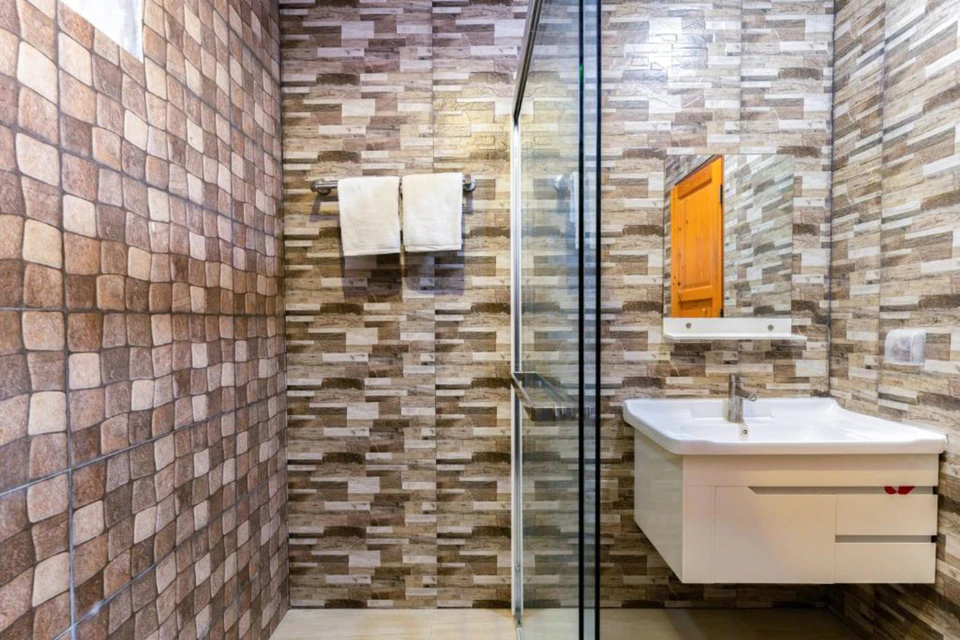 Tiled bathroom with vanity and glass shower enclosure