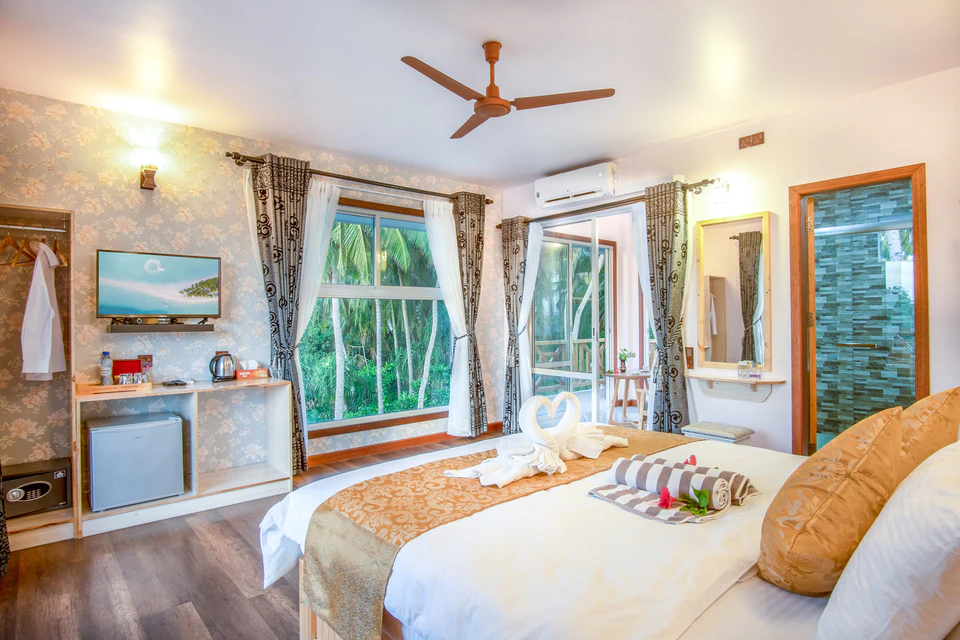 View from the bed toward the television, minibar, and corner windows